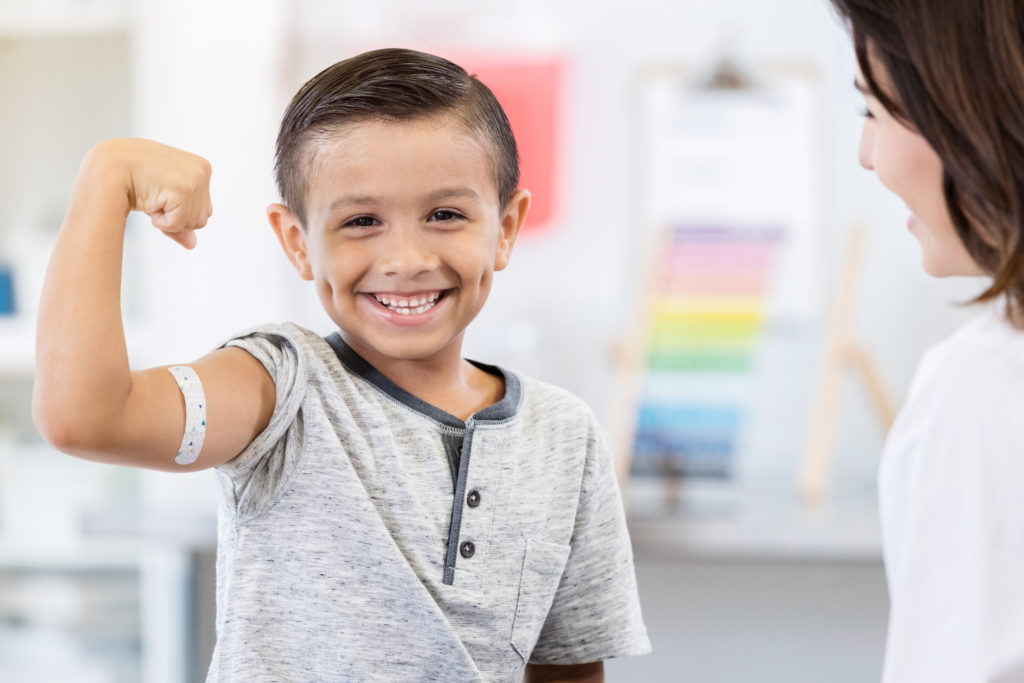Brave little boy shows off arm bandage at pediatrician